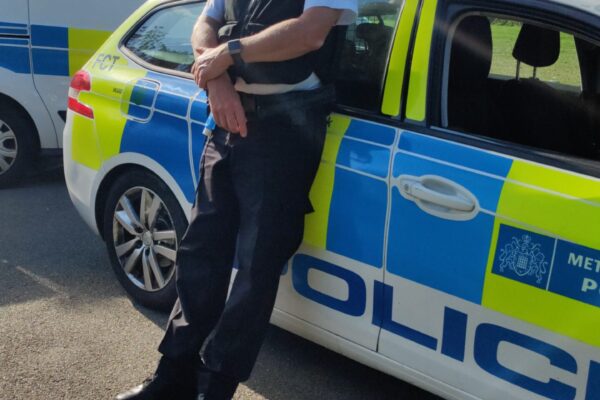 Awaiting CSI after finding gun Metropolitan Police Officer smiling beside car